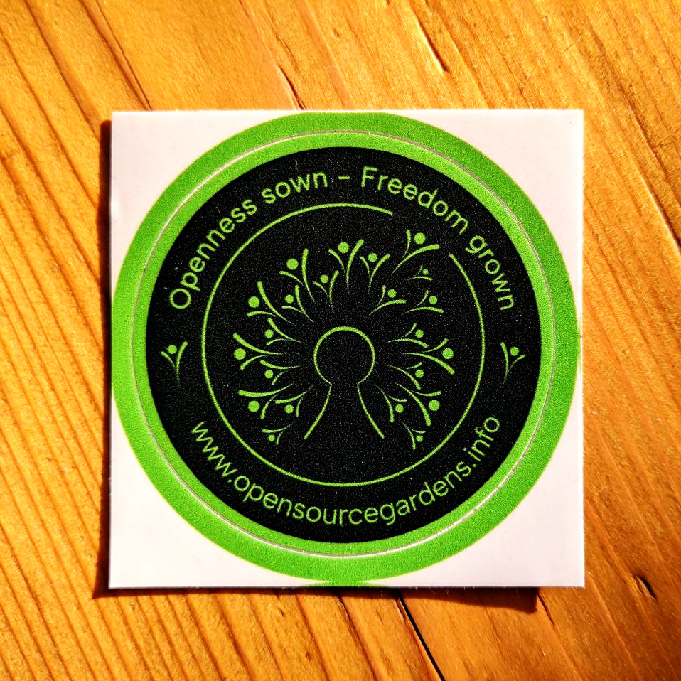 A photo of a sticker from Open Source Gardens, showing the logo, the slogan 